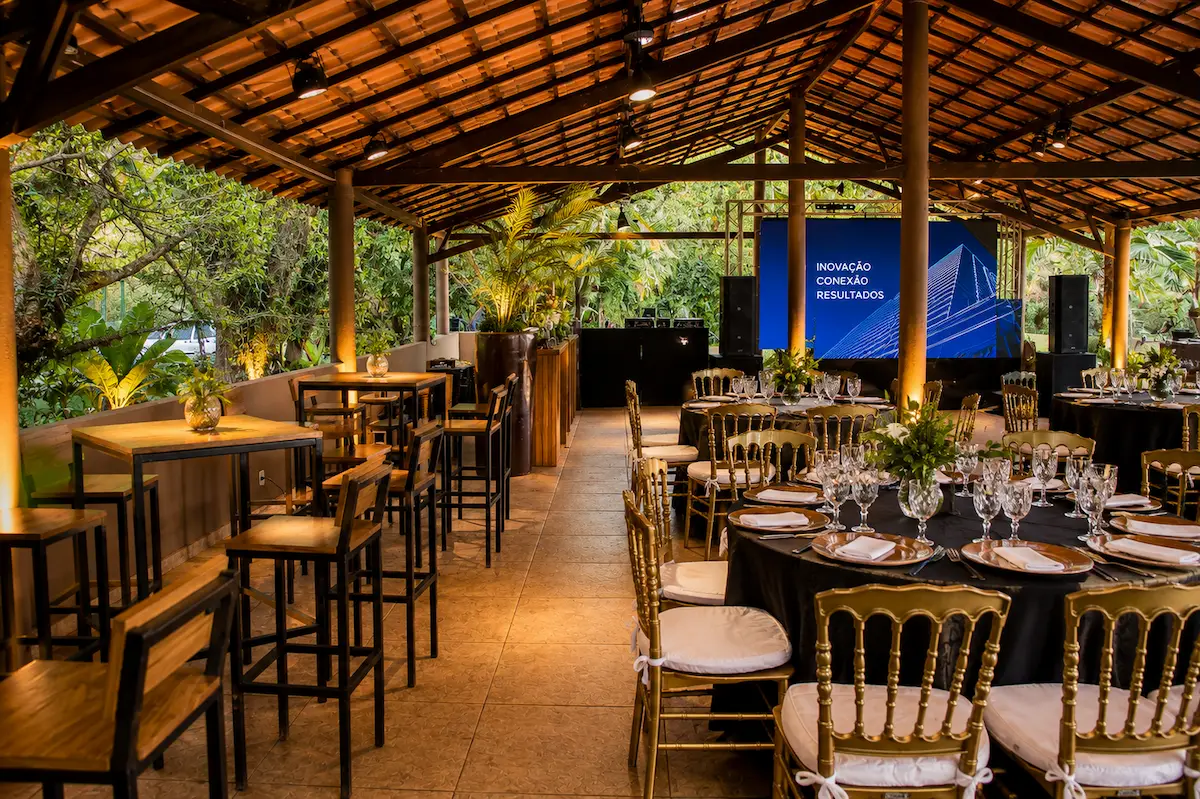 Pavilhão coberto montado para evento corporativo com telão e mesas